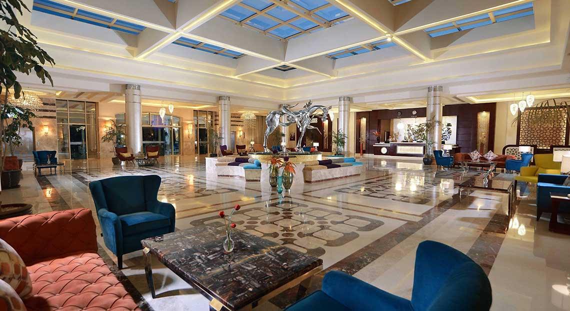 Lobby des Pickalbatros White Beach Resorts mit Möbeln und einem großen Brunnen.
