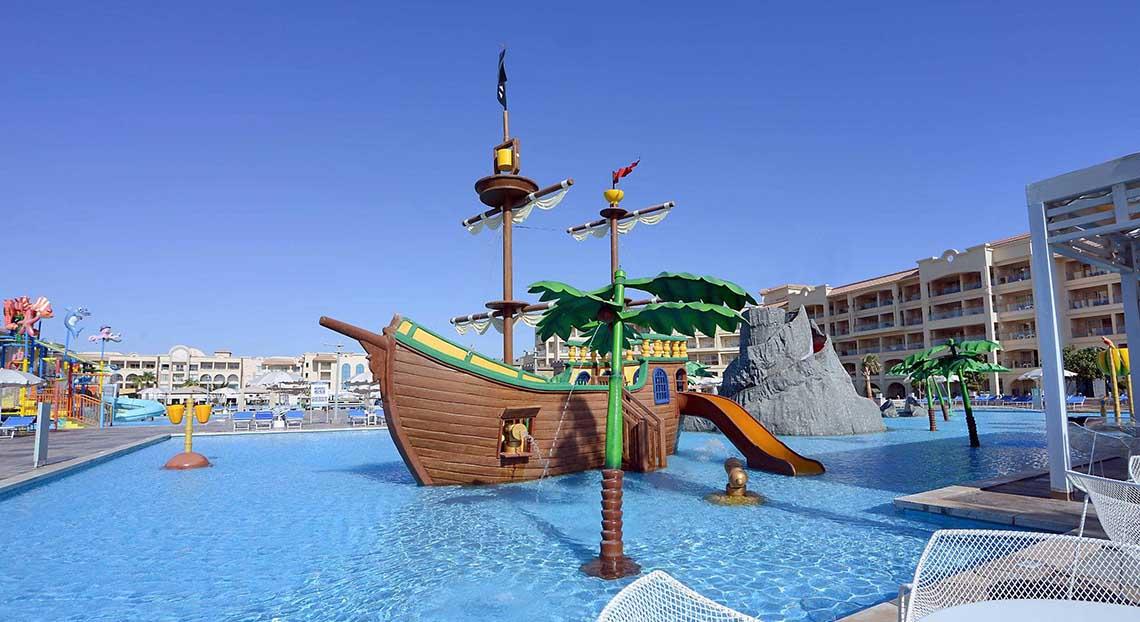 Wasserspielplatz im Pickalbatros White Beach Resort mit Piratenschiff, Rutsche und Palmen