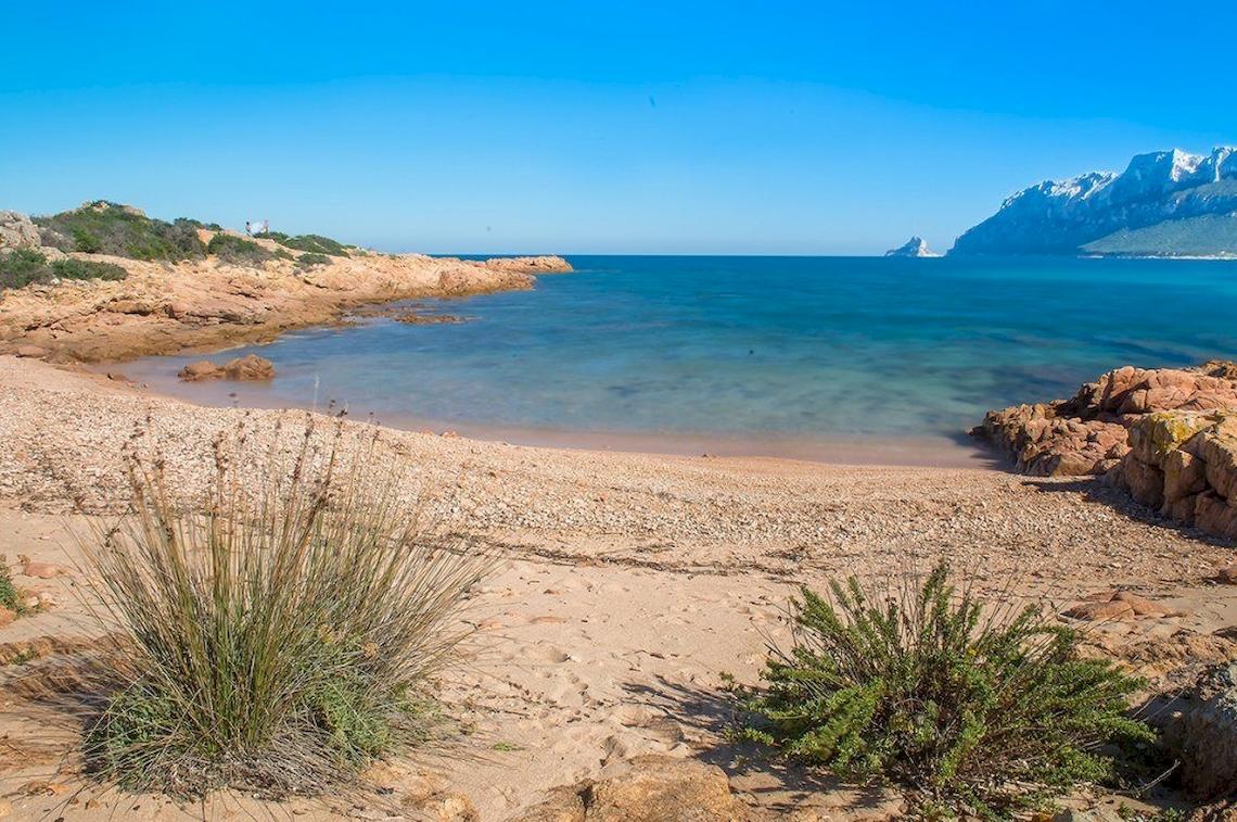 Hotel Ollastu Resort Strand mit blauem Meer und Felsen
