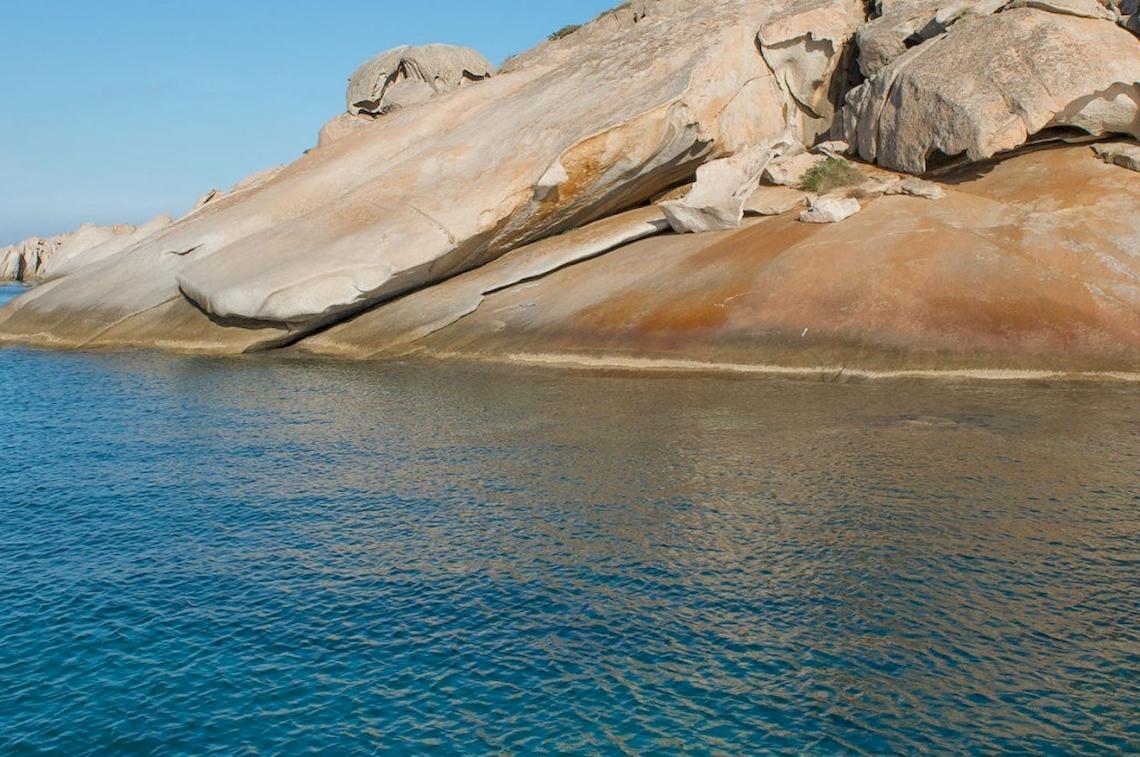 Felsige Küste am Meer mit kristallklarem Wasser und großen Felsbrocken