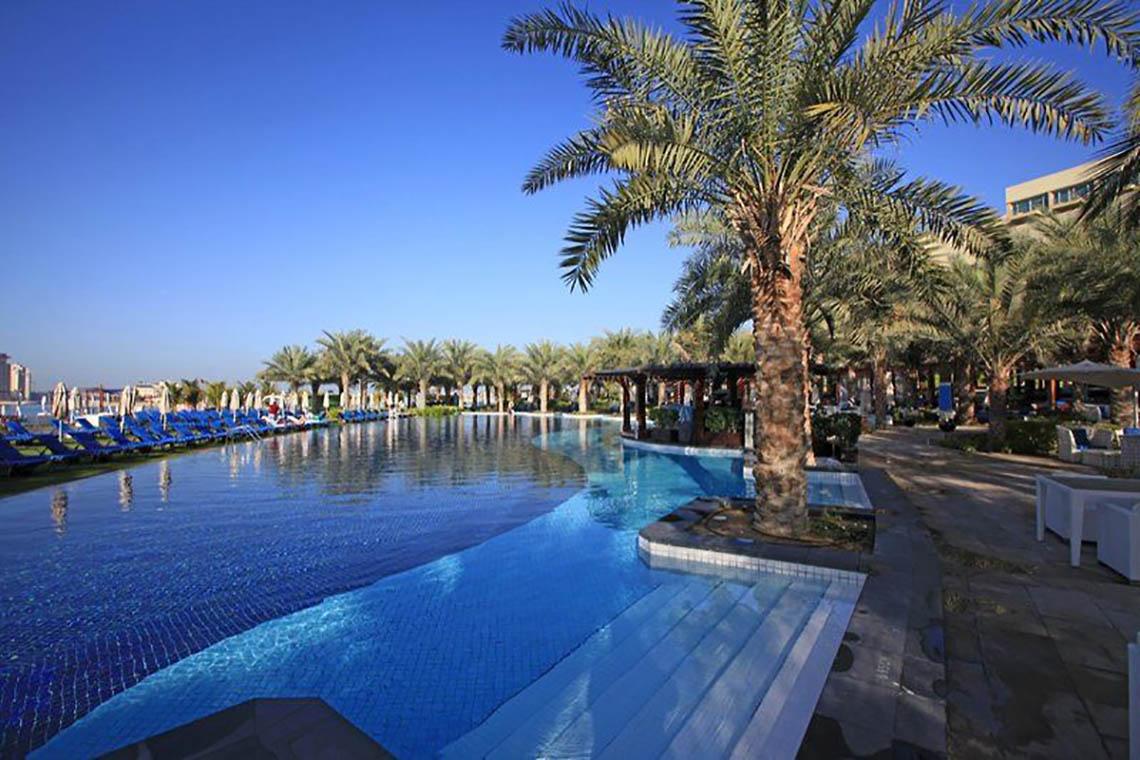 Rixos The Palm Hotel & Suites mit großem Pool und Palmen
