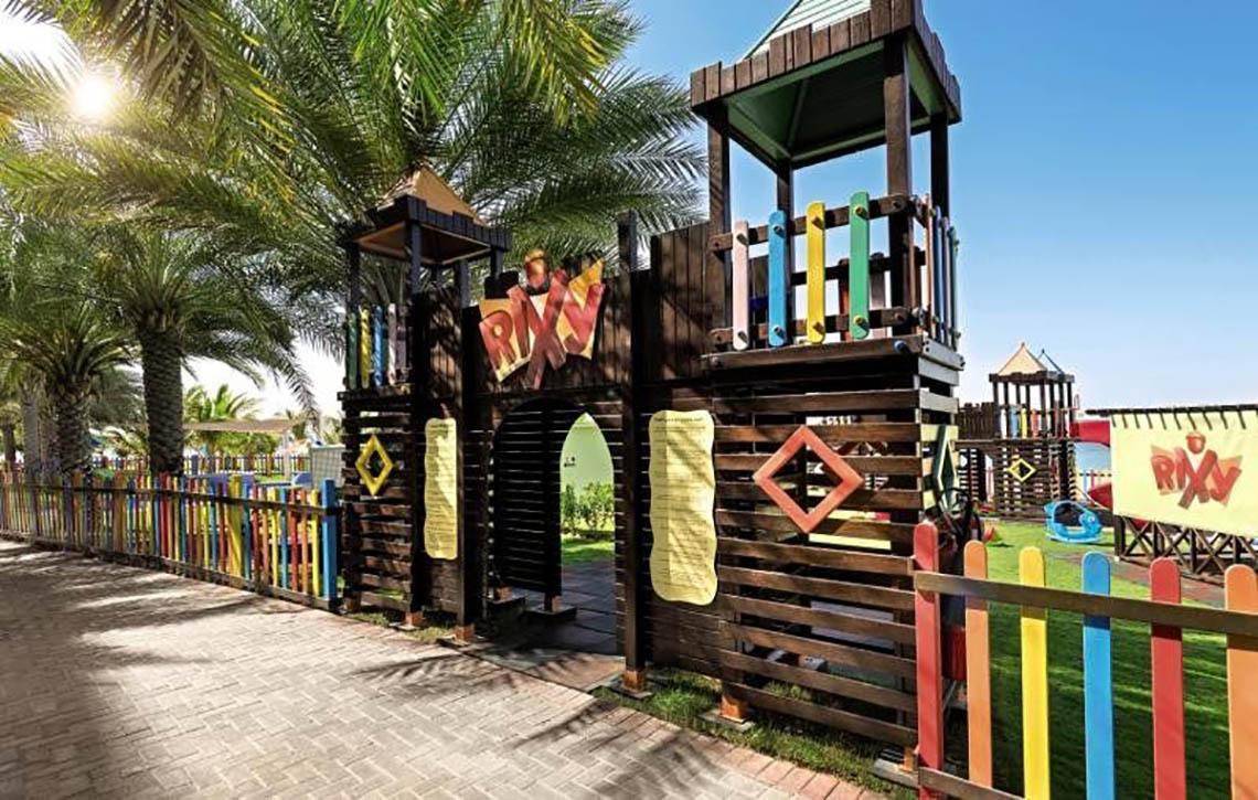 Kinderspielplatz im Rixos The Palm Hotel & Suites mit bunten Holzelementen und Spielturm