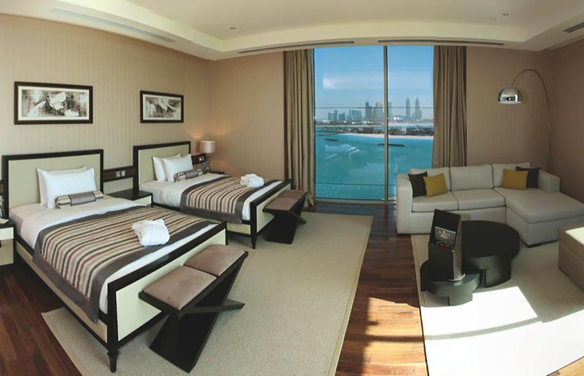 Suite mit Meerblick im Rixos The Palm Hotel & Suites mit zwei Betten und Wohnzimmerbereich.