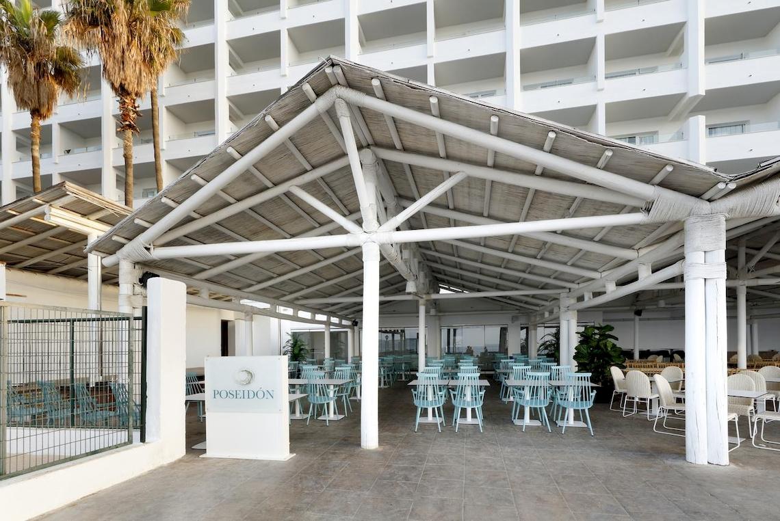 Außenbereich des Poseidon Restaurants im Playabonita Hotel mit Tischen und Stühlen unter einem Pavillon