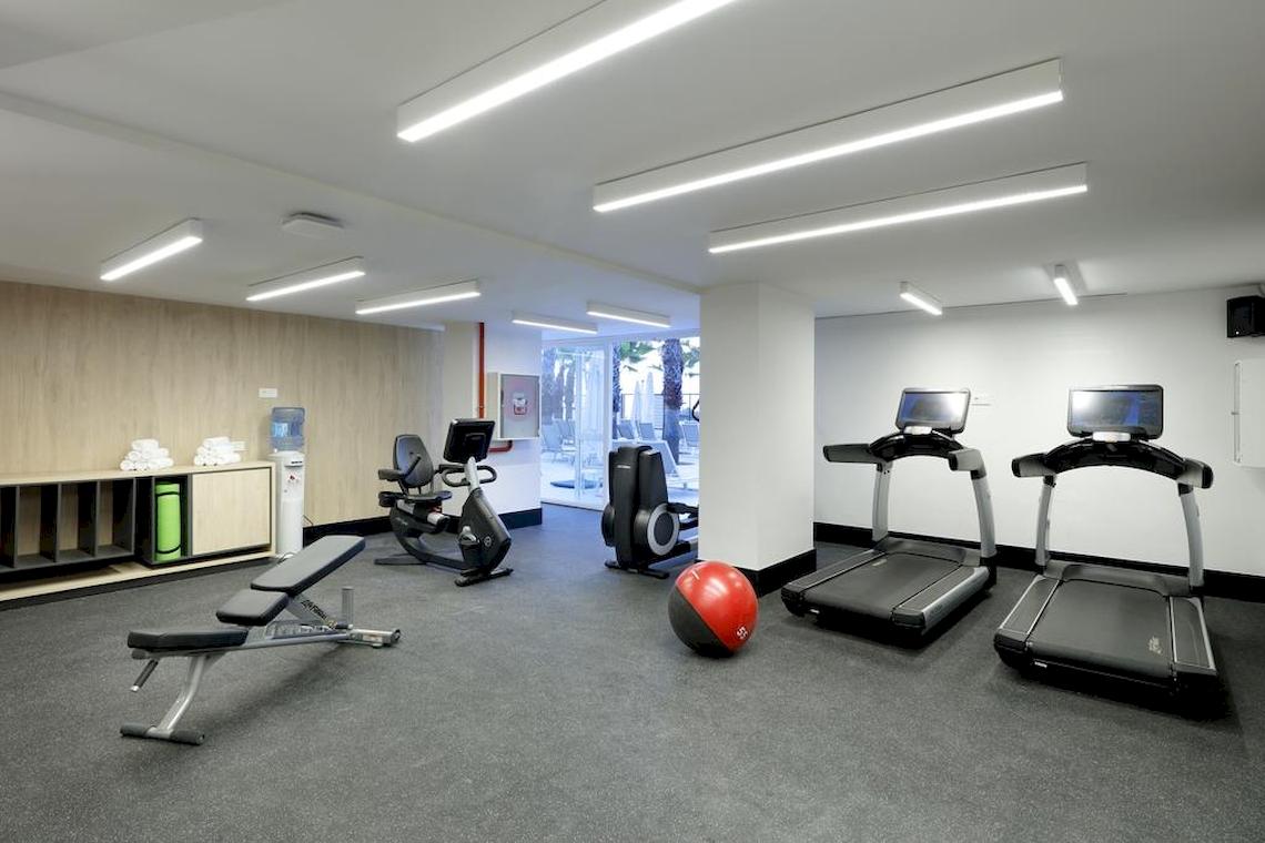 Fitnessraum im Playabonita Hotel mit Laufbändern, einer Bank und einem Medizinball.
