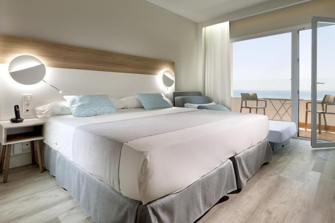 Hotelzimmer im Playabonita Hotel mit Meerblick, Doppelbett, Balkon und modernen Möbeln.