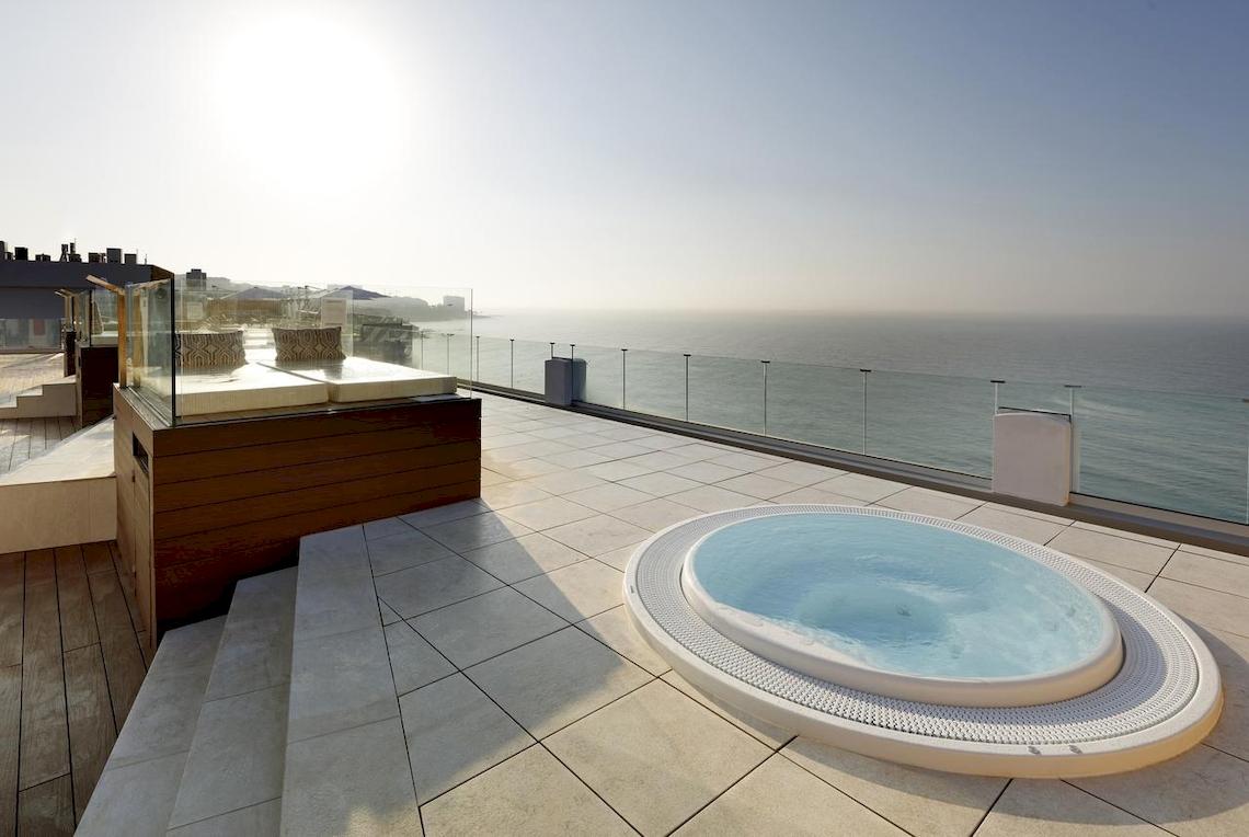 Terrasse des Playabonita Hotels mit Jacuzzi und Meerblick.