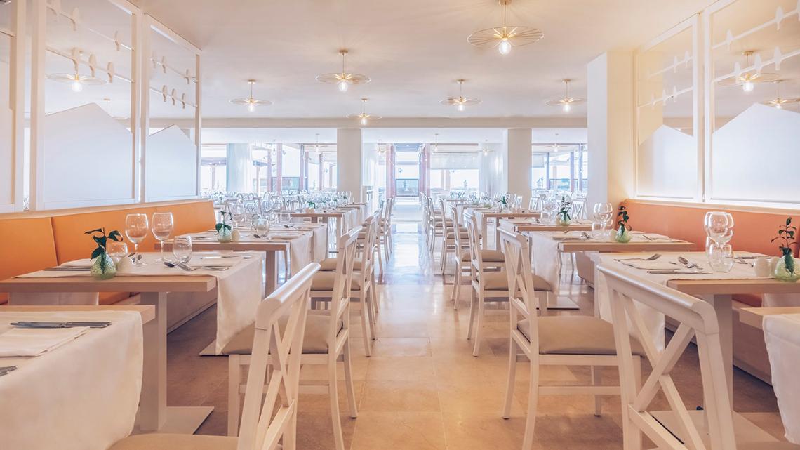 Innenansicht des Restaurants im Iberostar Selection Fuerteventura Palace Hotel mit weißen Tischen und Stühlen.