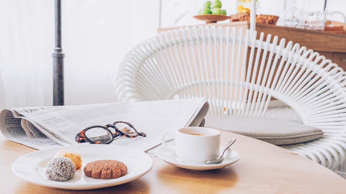 Frühstückstisch im Hotel Iberostar Selection Fuerteventura Palace mit Zeitung, Kaffee, Kuchen und Brille