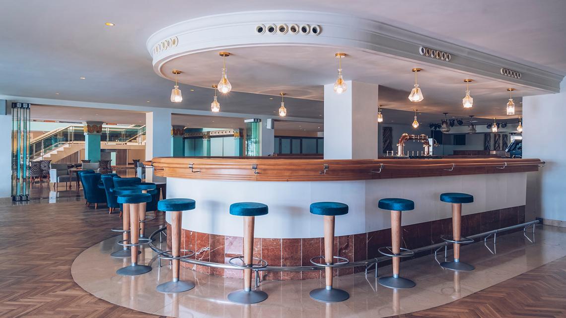 Bar im Iberostar Selection Fuerteventura Palace Hotel mit blauen Stühlen und runden Tresen.