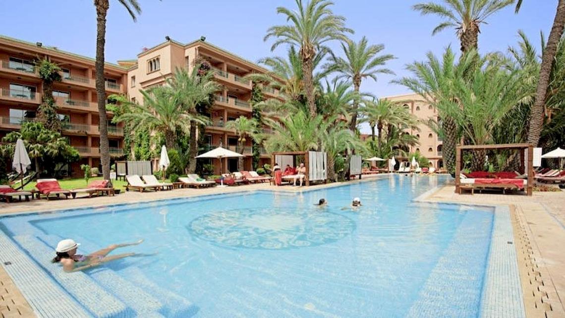 Schwimmbad des Sofitel Marrakech Lounge & Spa Hotels mit mehreren Schwimmern und Sonnenliegen.
