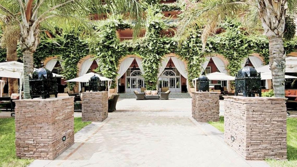 Eingangsbereich des Sofitel Marrakech Lounge & Spa mit steinernen Säulen und Palmen