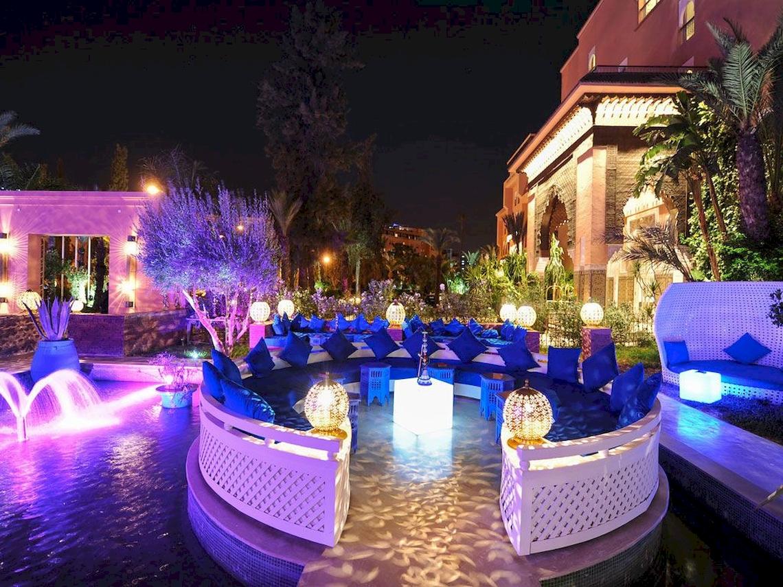 Außenbereich des Sofitel Marrakech Lounge & Spa bei Nacht mit blauen Beleuchtung und Wasserfontäne