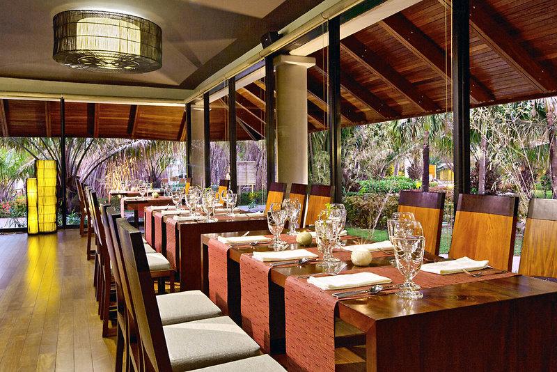 Innenbereich des Westin Reserva Conchal Golf Resorts mit gedeckten Esstischen und Blick auf den Garten
