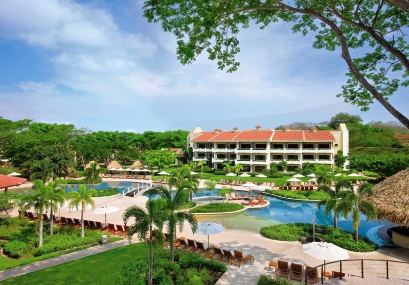 Außenansicht des Westin Reserva Conchal, einem All-Inclusive Golf Resort mit Swimmingpool und vielen Liegestühlen.