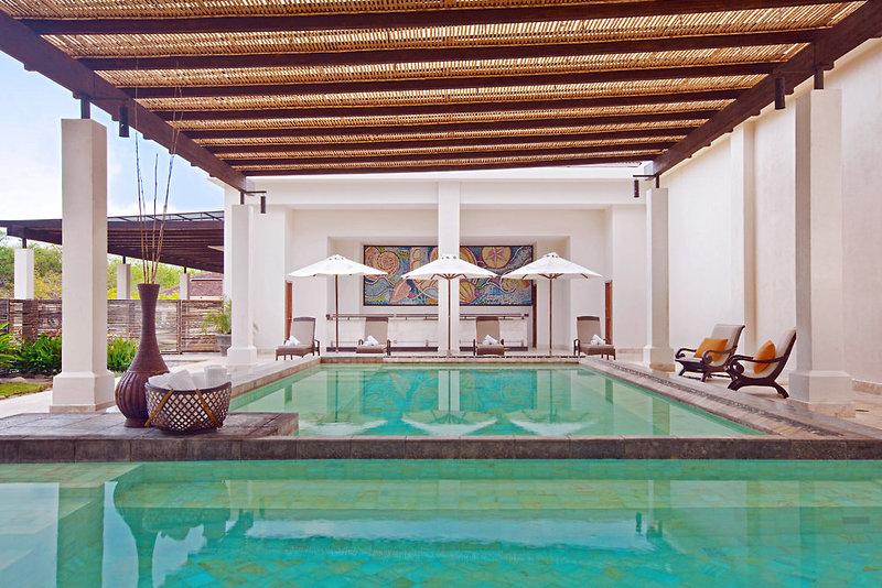 Außenpoolbereich des Westin Reserva Conchal mit überdachter Terrasse und Lounge-Stühlen.