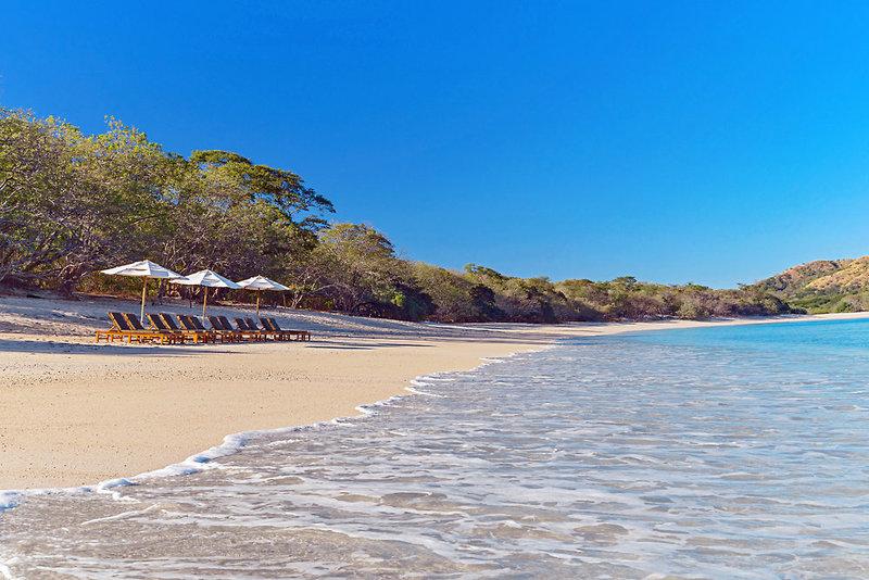 Strand des Westin Reserva Conchal mit Sonnenliegen und Sonnenschirmen