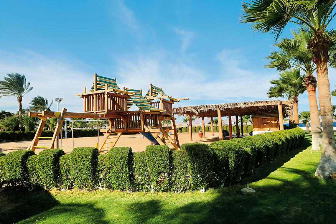 Freizeitbereich des Sharm Club Beach Resorts mit Spielplatz und Palmen