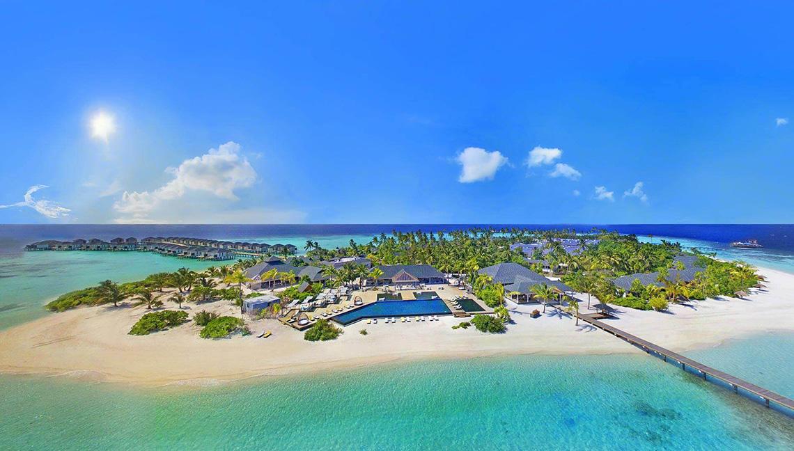 Luftaufnahme des Amari Havodda Maldives Resorts mit Pool, Steg und tropischen Inseln