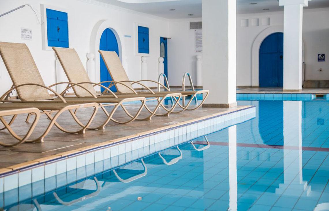 Reihe von Liegestühlen am Pool des Callisto Holiday Village
