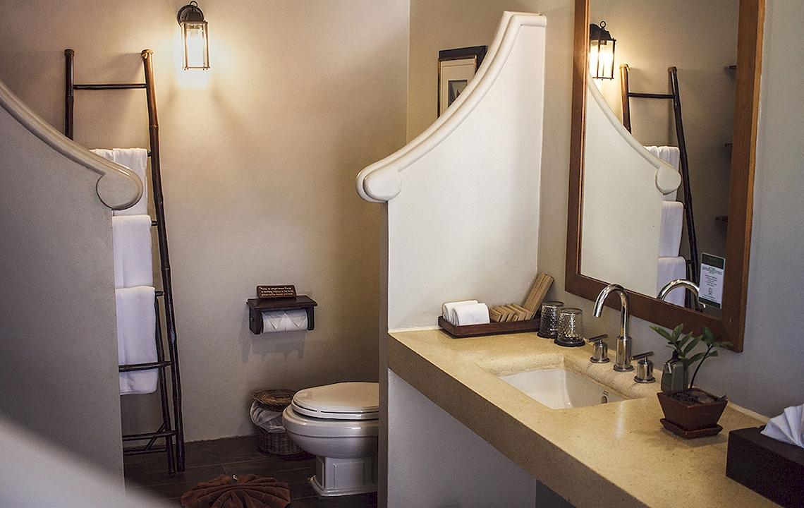 Innenansicht eines Badezimmers im Saree Samui Resort mit Toilette, Waschbecken und Spiegel.