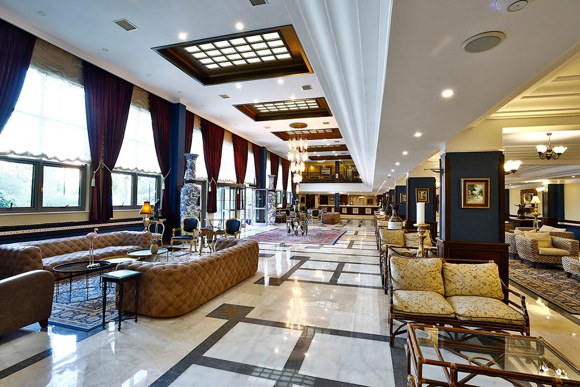 Club Yali Hotels & Resort Lobby mit Sofas, Tischen und Kronleuchtern.