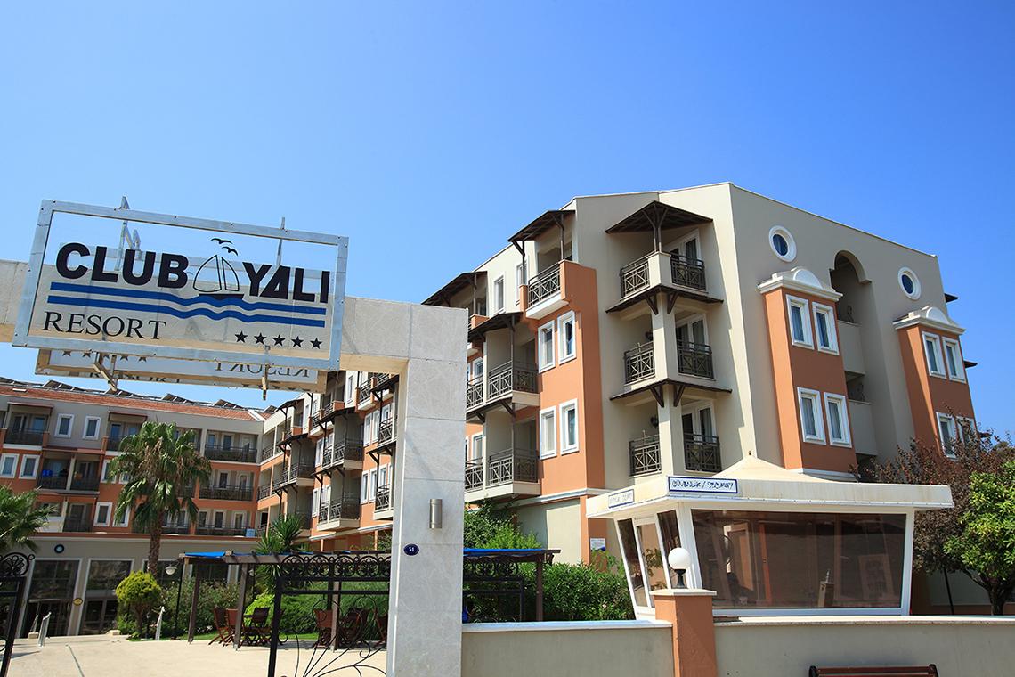 Eingang des Club Yali Hotels & Resort mit einem Schild, das den Namen des Resorts anzeigt.