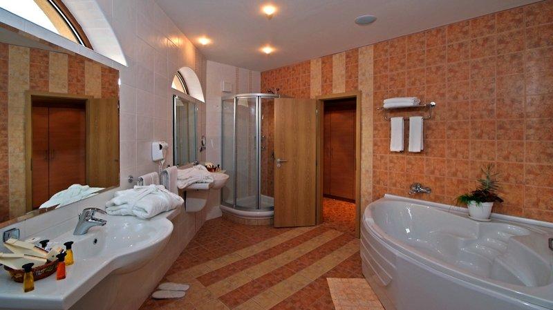 Badezimmer im Sol Nessebar Palace All Inclusive mit Badewanne, Dusche und zwei Waschbecken.