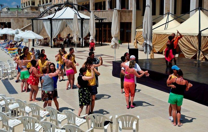 Gruppe von Menschen, die auf der Terrasse des Sol Nessebar Palace All Inclusive tanzen.