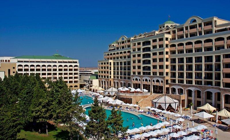 Außenansicht des Sol Nessebar Palace All Inclusive Hotels mit Swimmingpool und Sonnenschirmen.