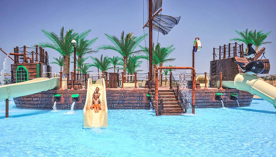 Wasserpark mit Piratenschiff im Jaz Aquaviva Hotel, Kinder rutschen auf einer Rutsche hinunter.