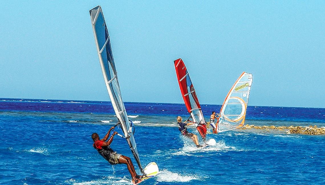 Segelsurfer im Ozean während eines blauen und sonnigen Tages.