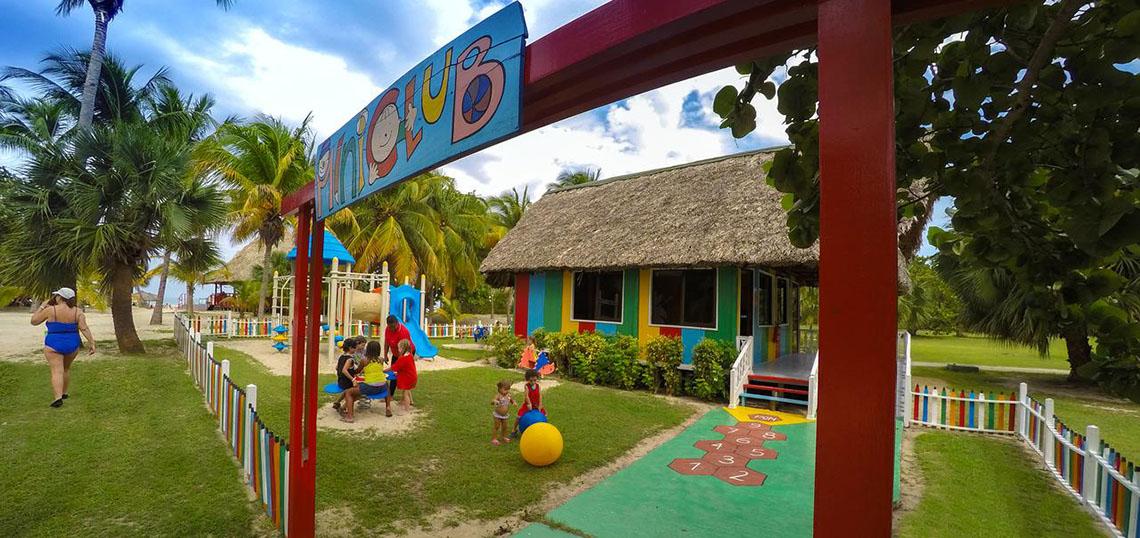 Kinderclub im ROC Arenas Doradas Hotel mit buntem Gebäude und Spielgeräten im Freien.