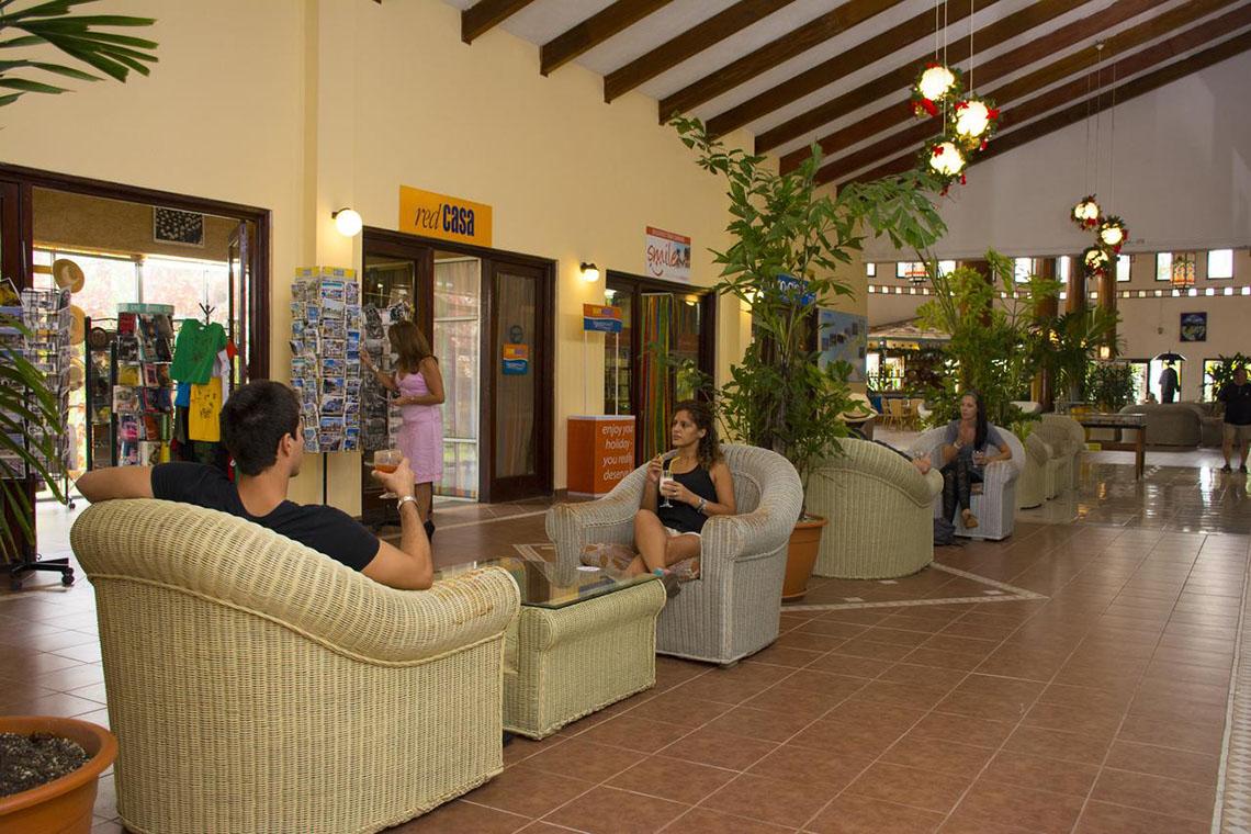 Gäste sitzen in der Lobby des ROC Arenas Doradas Hotels und trinken Getränke.
