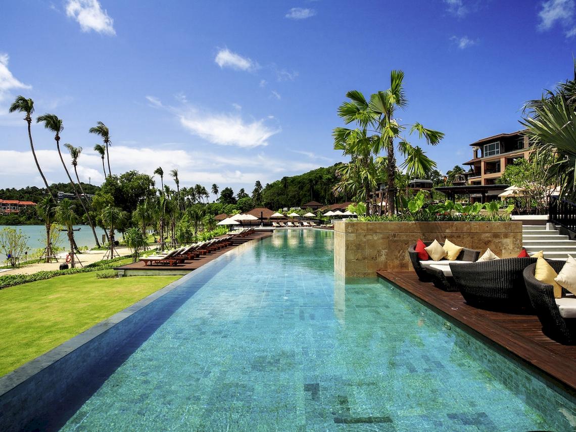 Infinity-Pool im Pullman Phuket Panwa Beach Resort mit Lounge-Bereich und Blick auf das Meer