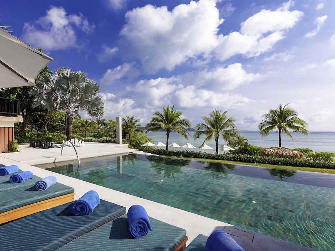 Außenpool mit Liegen und Blick auf das Meer im Pullman Phuket Panwa Beach Resort