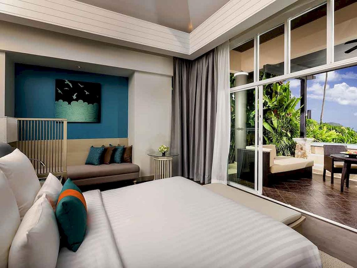 Schlafzimmer im Pullman Phuket Panwa Beach Resort mit Blick auf den Garten