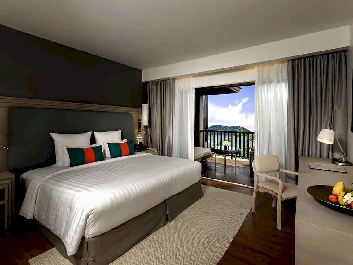 Luxuriöses Zimmer mit Meerblick im Pullman Phuket Panwa Beach Resort mit großem Bett, Balkon und Ausblick auf das Meer.