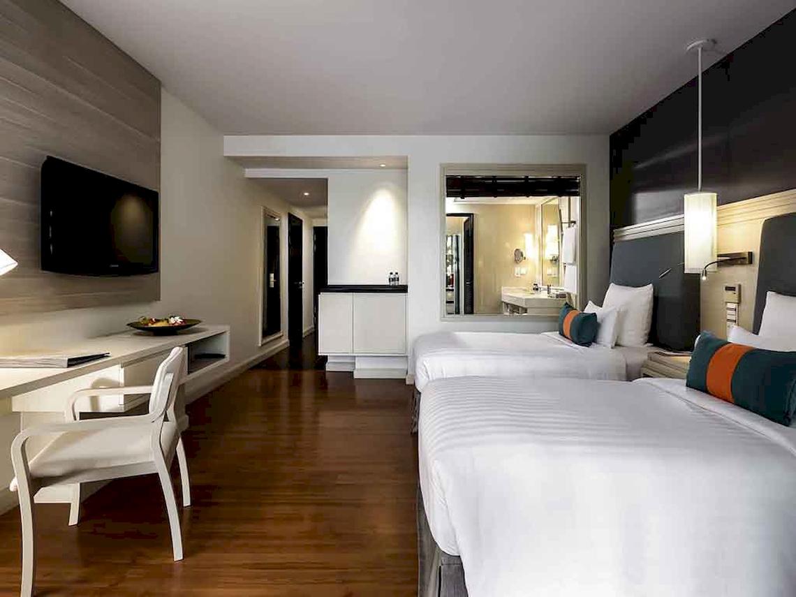 Hotelzimmer im Pullman Phuket Panwa Beach Resort mit zwei Betten, Schreibtisch und Fernseher