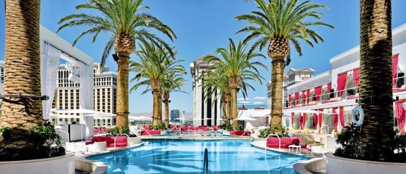 Poolbereich im The Cromwell Las Vegas Hotel & Casino mit roten Sonnenliegen und Palmen