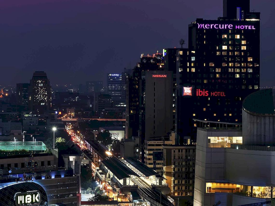 Abendliche Stadtansicht von Bangkok mit dem Mercure Hotel und anderen Hochhäusern.
