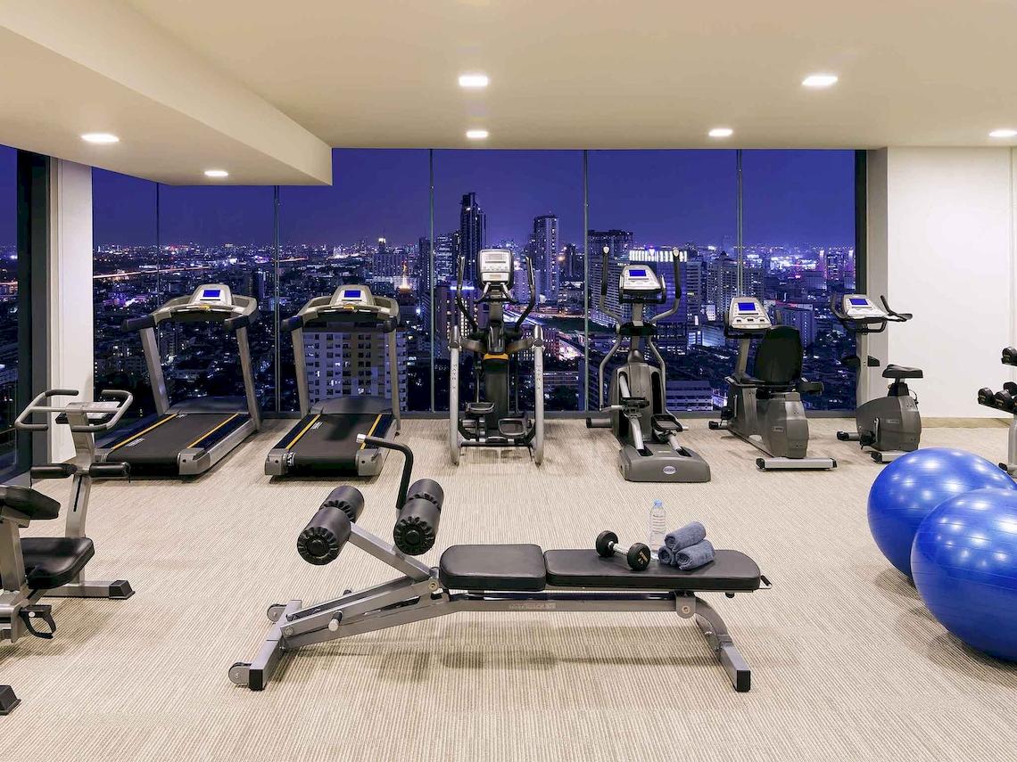 Fitnesscenter-Innenbereich im Mercure Bangkok Siam mit Blick auf die Stadt