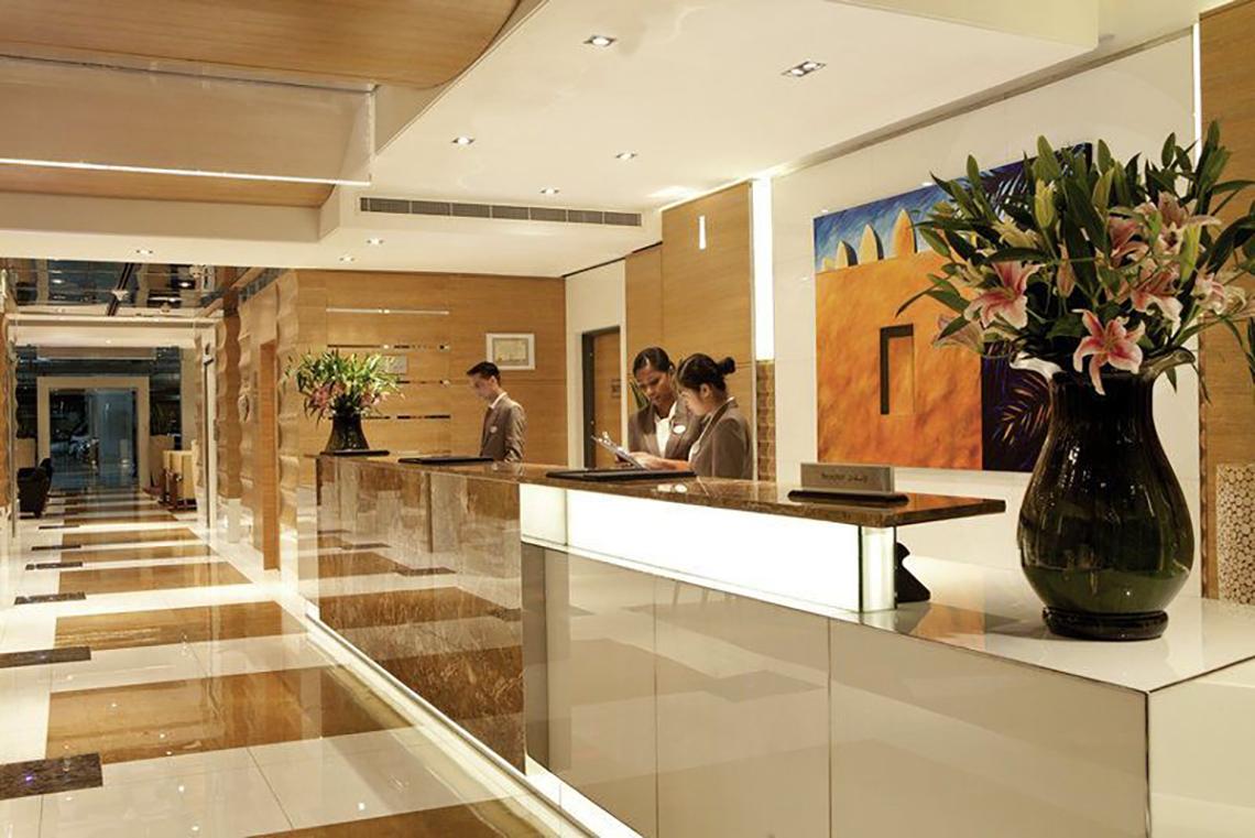 Lobby des Delta Hotels by Marriott Jumeirah Beach mit Rezeption und Gäste, die sich anmelden.
