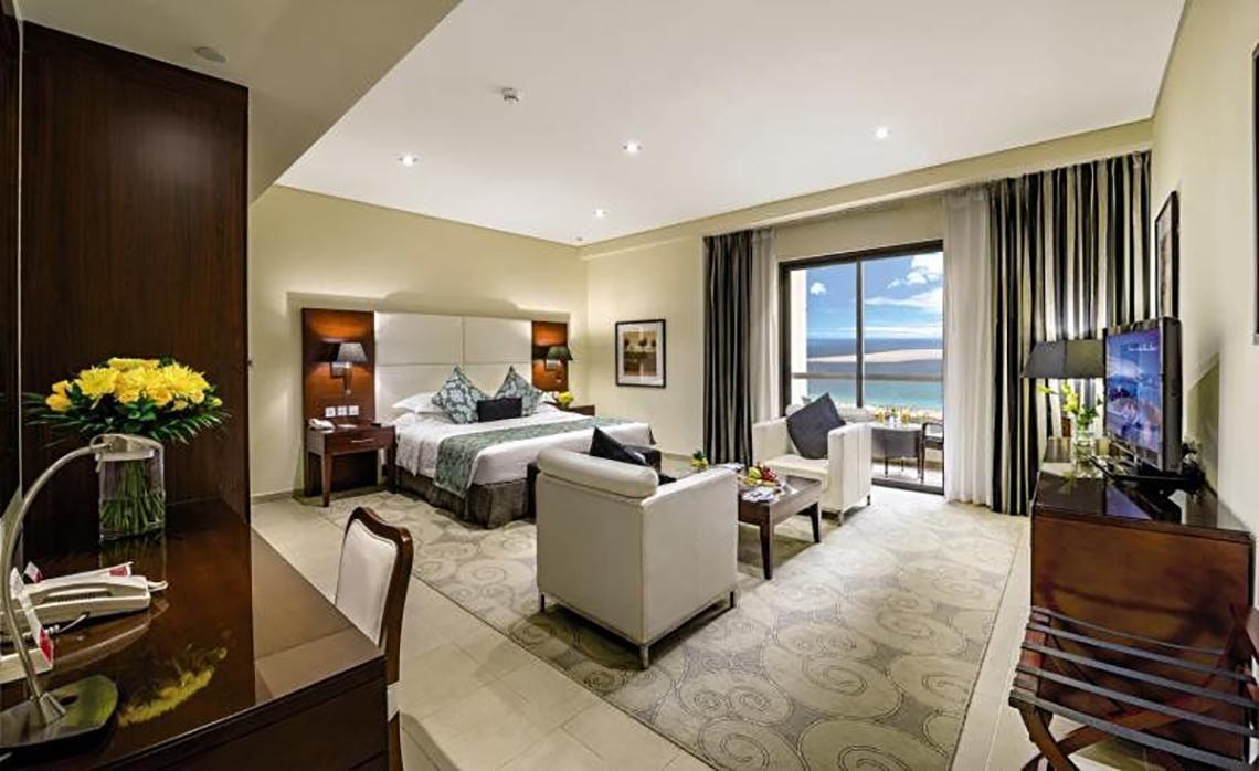Hotelzimmer im Delta Hotels by Marriott Jumeirah Beach, Dubai mit Bett, Sitzbereich, Fernseher und Meerblick.