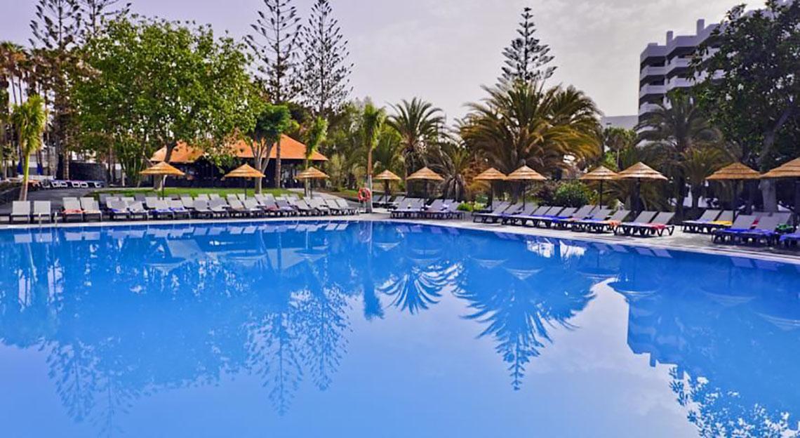 Außenpool des Barcelo Margaritas Hotels mit Sonnenliegen und Sonnenschirmen.