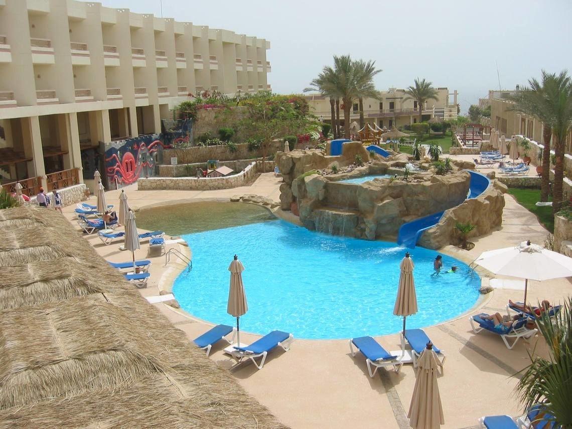 Ein Hotelpool mit Wasserrutsche und Liegestühlen im DoubleTree by Hilton Sharks Bay Resort.