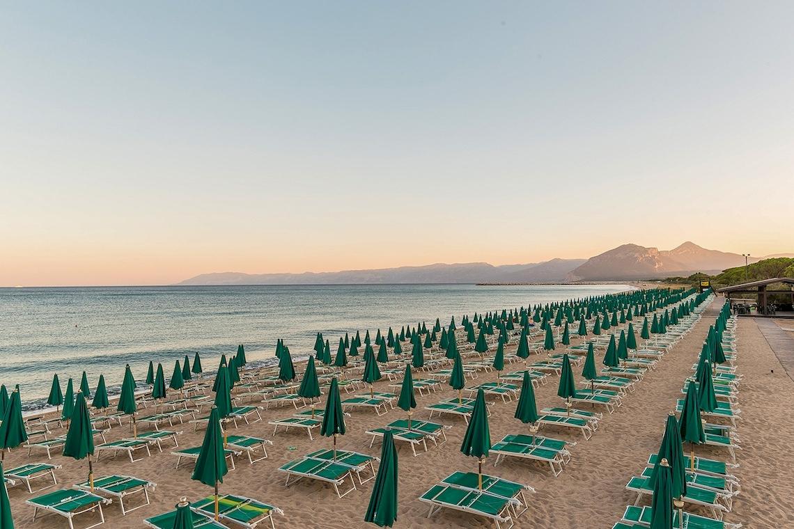 Strand des Club Hotel Marina Beach mit vielen Sonnenschirmen und Liegen.