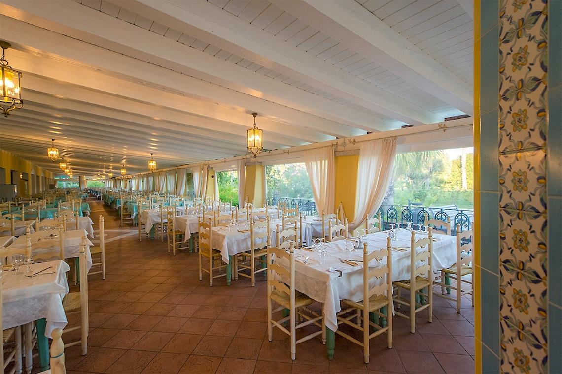 Foto von einem Restaurantbereich im Club Hotel Marina Beach mit vielen gedeckten Tischen und Stühlen.