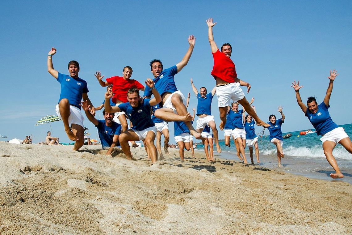 Gruppe junger Männer und Frauen springt am Strand des Club Hotel Marina Beach