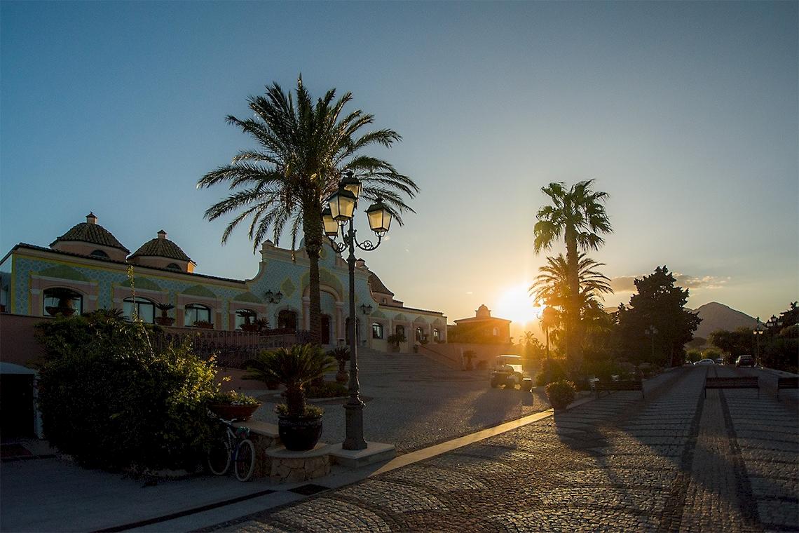 Sonnenuntergang am Club Hotel Marina Beach mit Palmen und Gehweg.